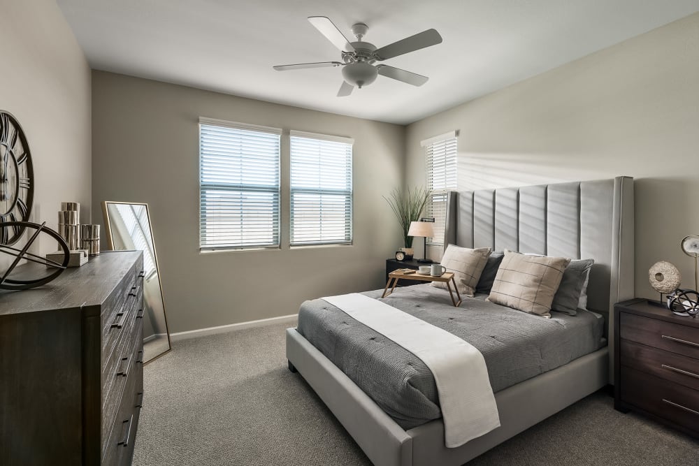 Brightly lit bedroom with ceiling fan to keep you cool at Las Casas at Windrose in Litchfield Park, Arizona