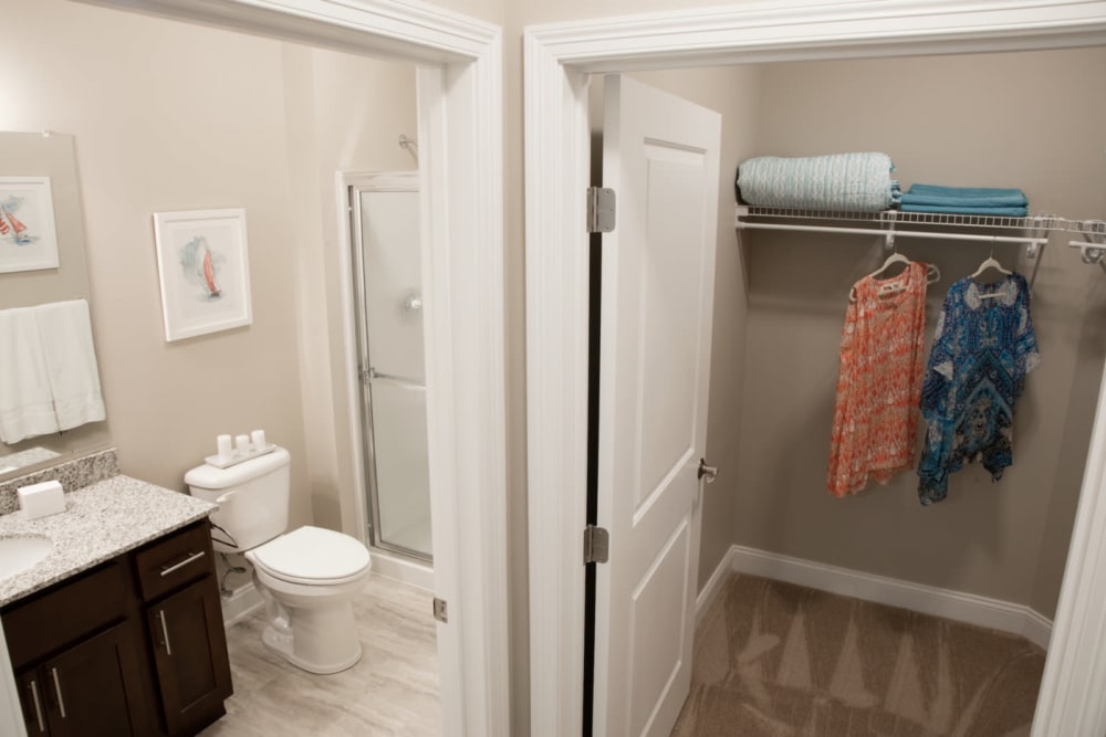 View into a walk-in closet and master bathroom at Highcroft Apartment Homes in Simsbury, Connecticut