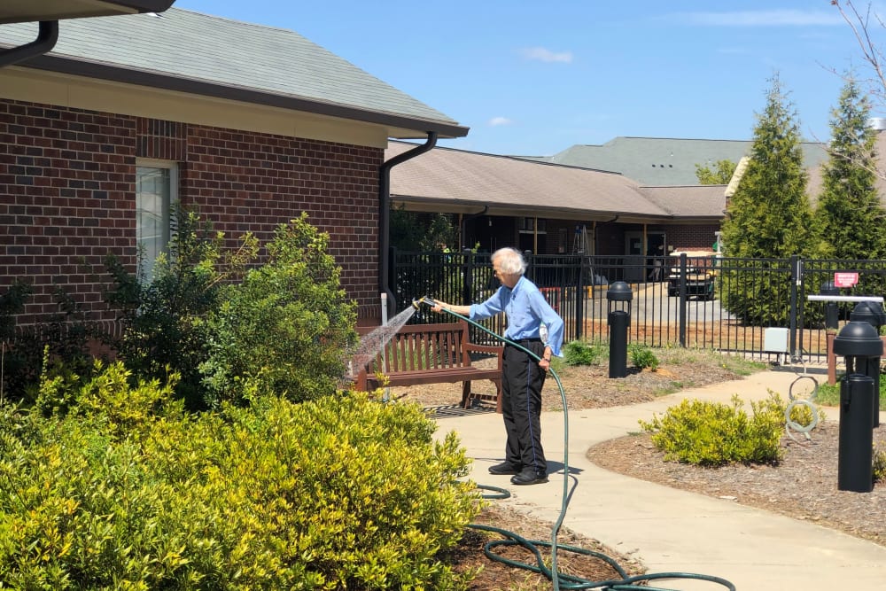 Resident watering shrubs at The Foothills Retirement Community in Easley, South Carolina