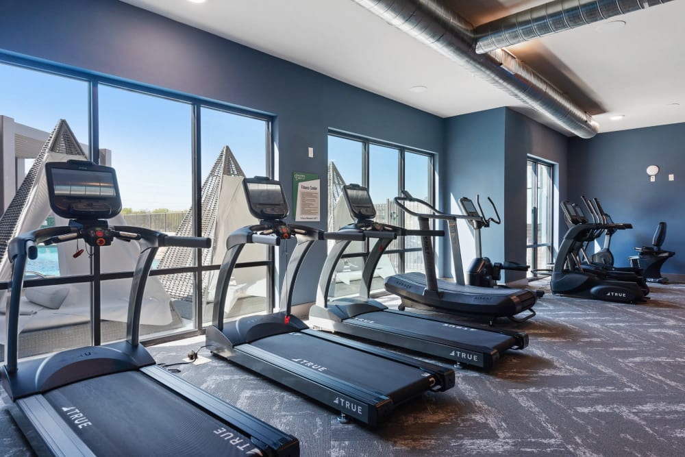Community fitness area featuring several treadmills looking out large windows at Discovery Park in Denton, Texas