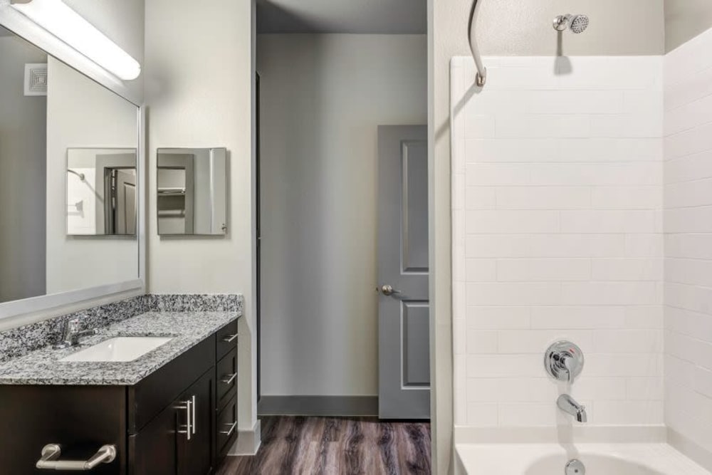 Full bathroom with granite countertop and a shower and bath combo at Discovery Park in Denton, Texas