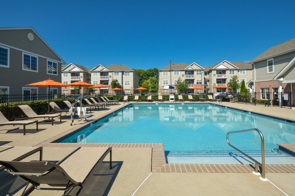 Sparkling pool with lounge chairs and umbrellas at Aspen Court, Piscataway, New Jersey