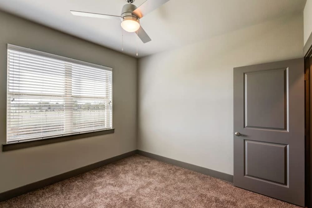Carpeted bedroom with ceiling fan at Discovery Park in Denton, Texas