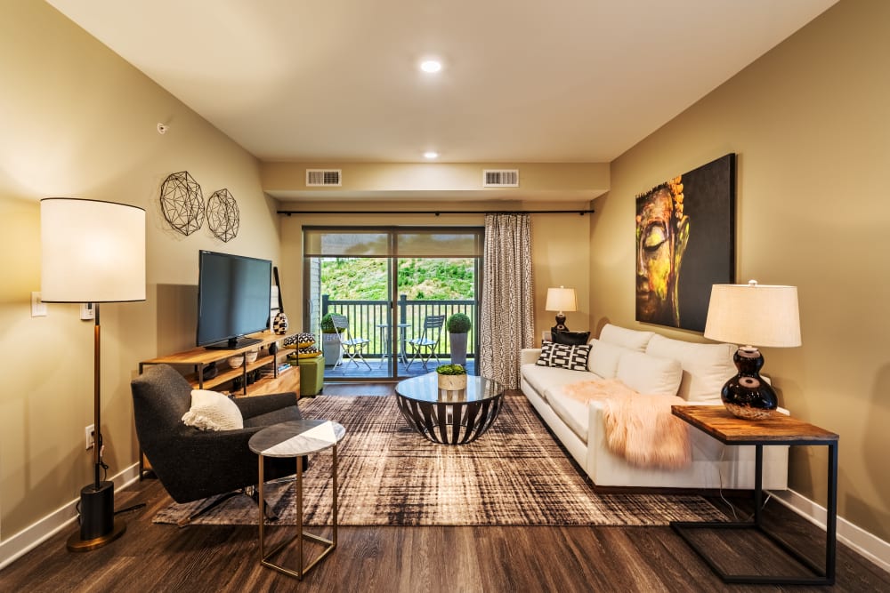 Living room with wood flooring and large windows at Cosmopolitan Apartments in Pittsburgh, Pennsylvania