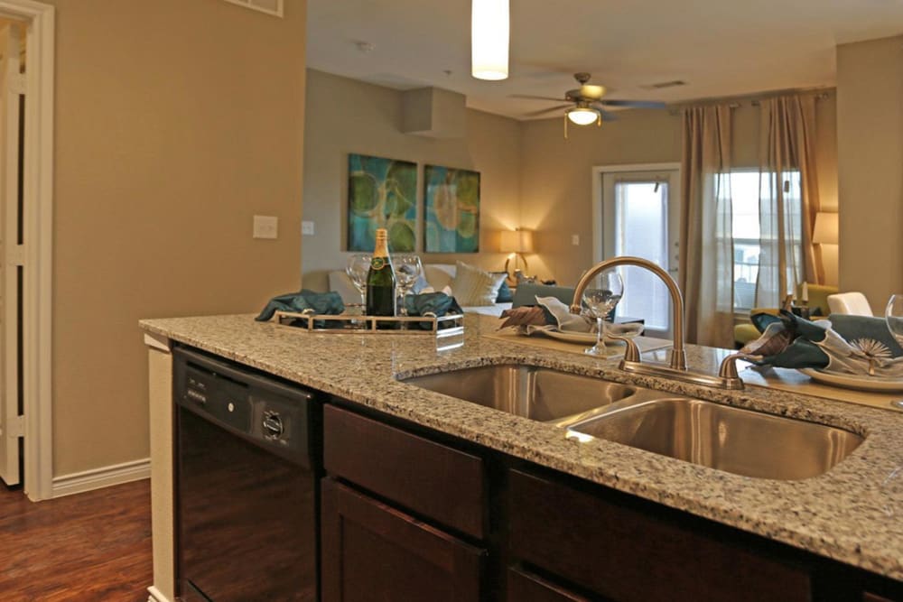 Fully-equipped kitchen featuring granite countertops, island seating, and modern appliances at Latigo at Eagle Pass in Eagle Pass, Texas