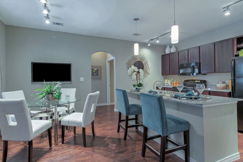 Beautifully staged kitchen and dining area with island seating at Latigo at Eagle Pass in Eagle Pass, Texas