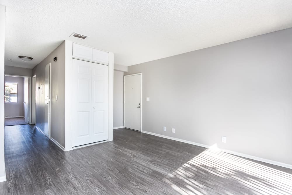 Open living room wit hardwood floors and white walls at Sierra Vista Apartments in Redlands, California