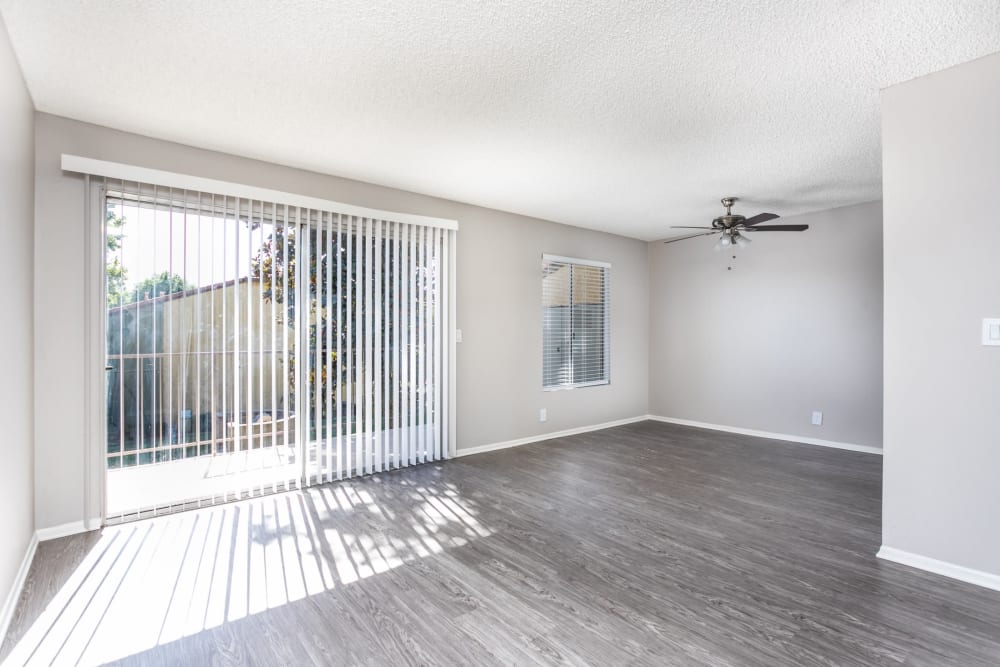 Spacious open concept living room with sliding door to patio at Sierra Vista Apartments in Redlands, California
