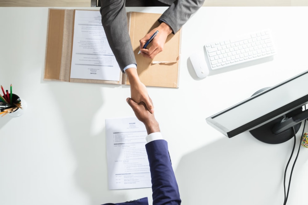 Handshake over a table at Robbins Property Associates, LLC in Tampa, Florida