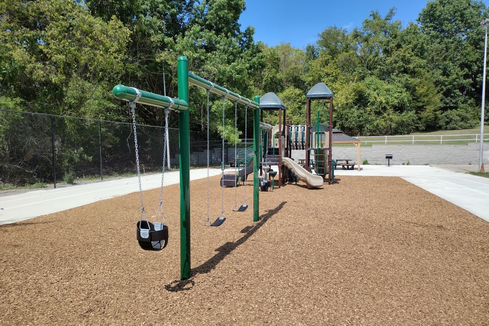 Community area featuring charcoal grills and a playground at Pebble Creek Apartments in Antioch, Tennessee