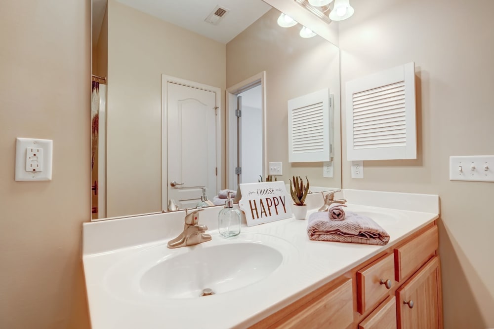 Bathroom with wood cabinets and kitchen sink at Carden Place Apartment Homes