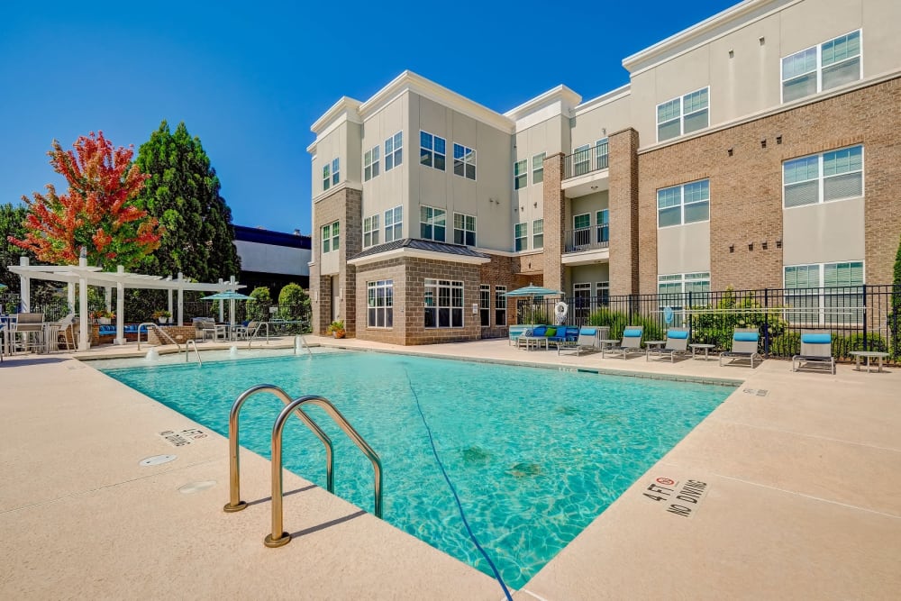 Outdoor swimming pool area at Reserve at Kenton Place Apartment Homes in Cornelius, North Carolina