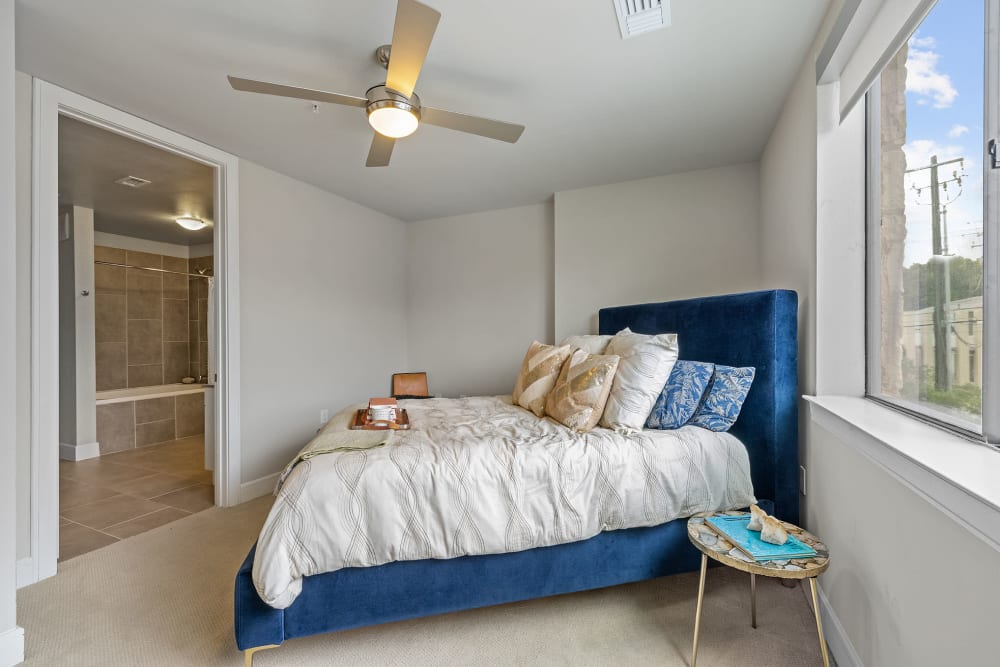 Large bedroom with natural light and ceiling fan and carpet at Water Marq in Austin, Texas