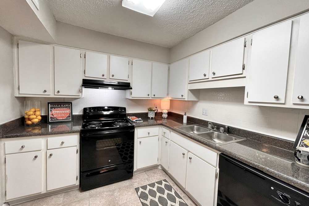Stainless steel stove, drawer microwave, and sink with granite countertops at The Abbey at Regent's Walk in Homewood, Alabama