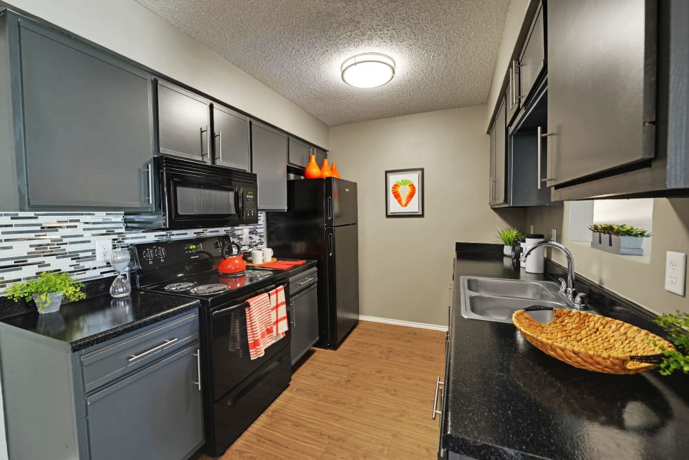 Modern kitchen with dark finishes at Spice Creek in San Antonio, Texas