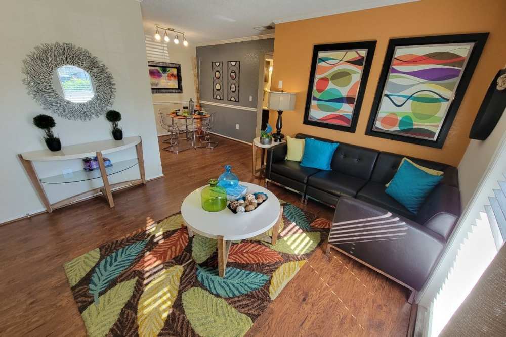 A decorated modern living room with a comfortable couch, colorful carpet and round coffee table at The Abbey At Northlake in Riviera Beach, Florida