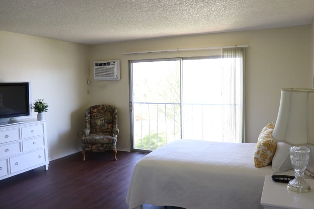 Spacious resident bedroom with sliding door to patio at Sun City Gardens in Sun City, California