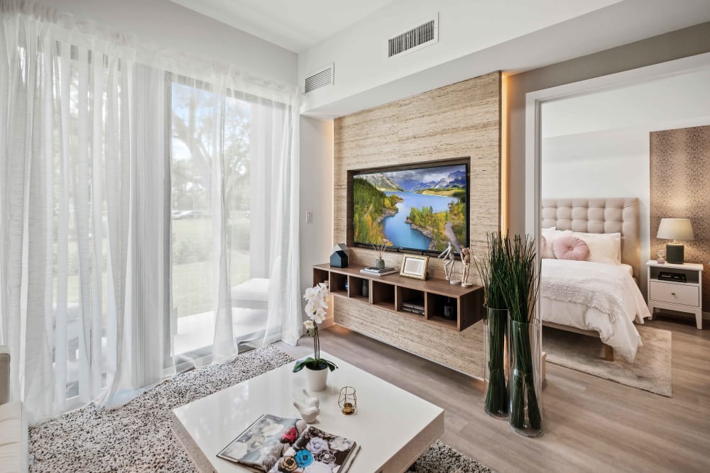 Model living space leading into bedroom at Oak Enclave in Miami Gardens, Florida