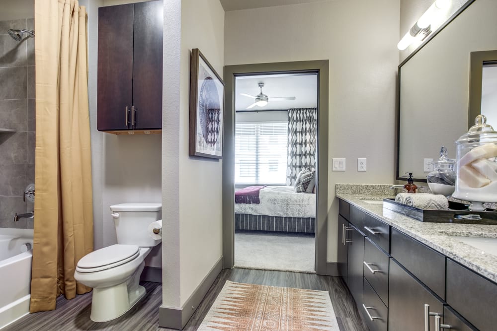Bathroom with granite countertop and dual basins at Oro Stone Oak in San Antonio, Texas