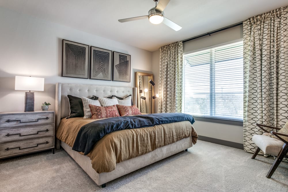 Brightly lit bedroom with ceiling fan at Oro Stone Oak in San Antonio, Texas