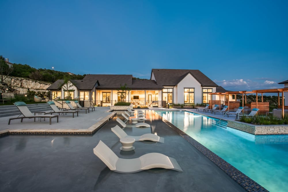 Community pool with luxury lounge chairs at Oro Stone Oak in San Antonio, Texas