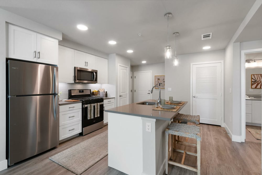 An island and stainless-steel appliances in a kitchen at Alivia Townhomes in Whittier, California