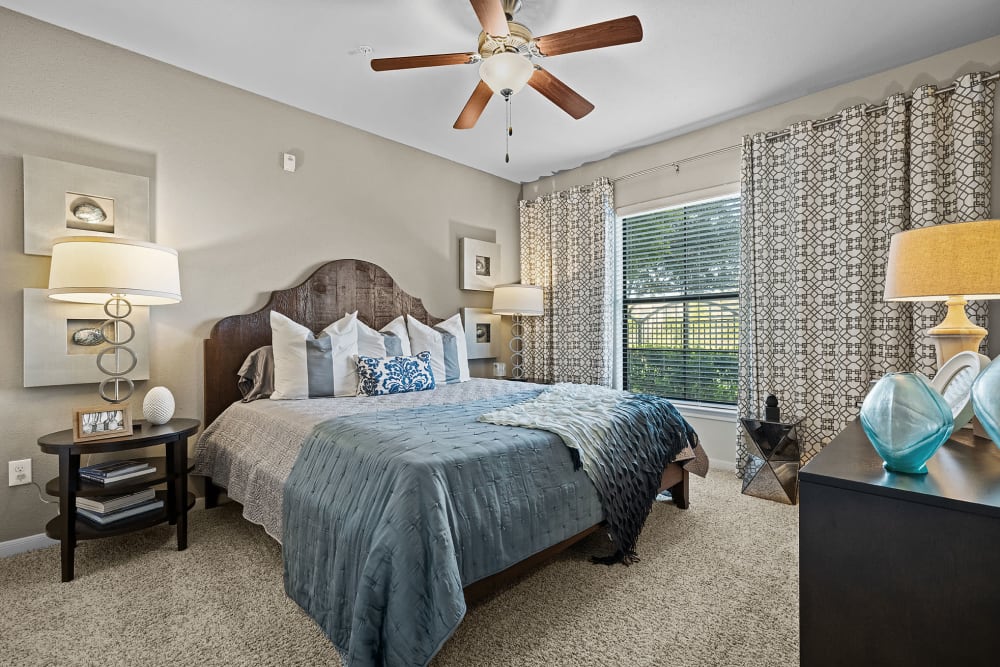 Spacious carpeted bedroom with multiple windows at Marquis at the Reserve in Katy, Texas
