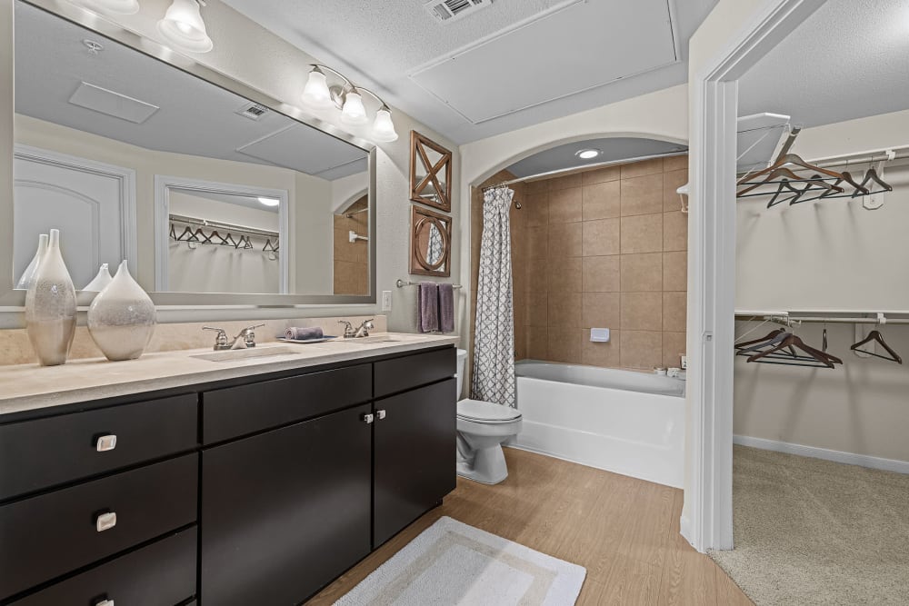 Modern style bathroom with large bathtub and wood flooring at Marquis at the Reserve in Katy, Texas