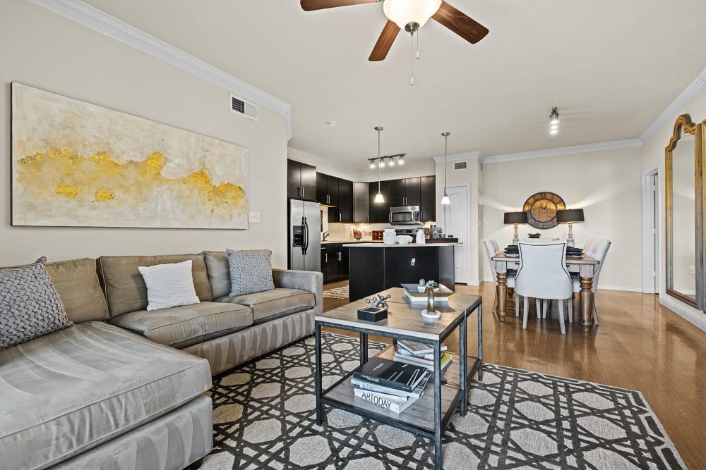 Modern style living room with wood flooring and ceiling fan at Marquis at the Reserve in Katy, Texas