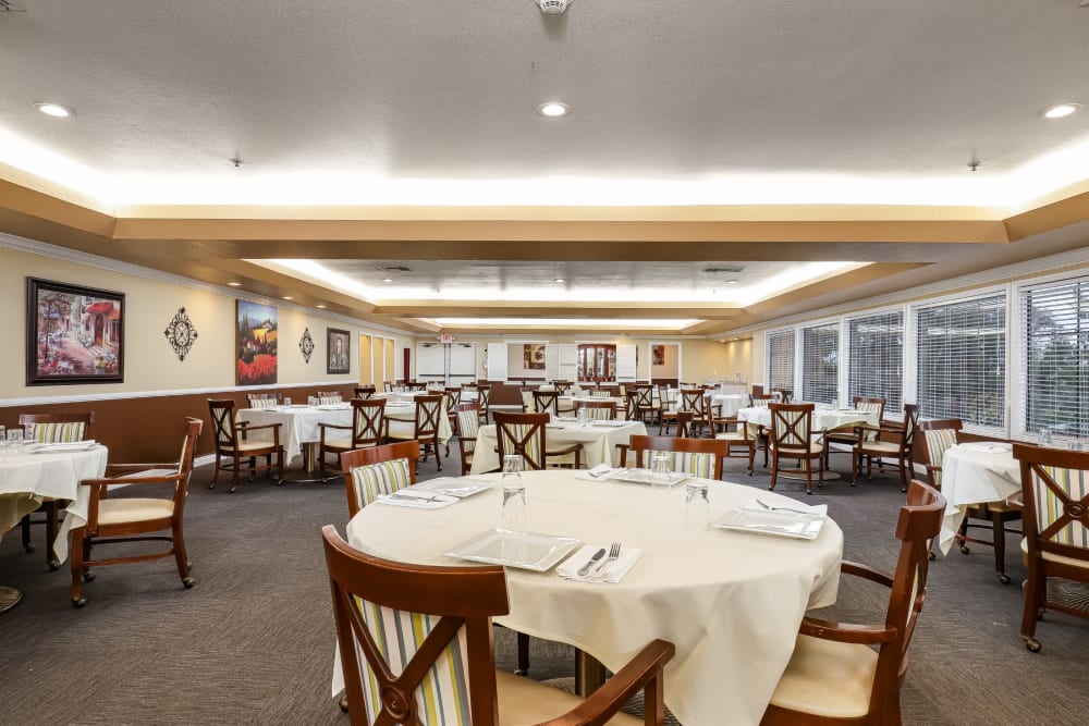 Resident dining room with plenty of seating and large windows at Pacifica Senior Living Poway in Poway, California