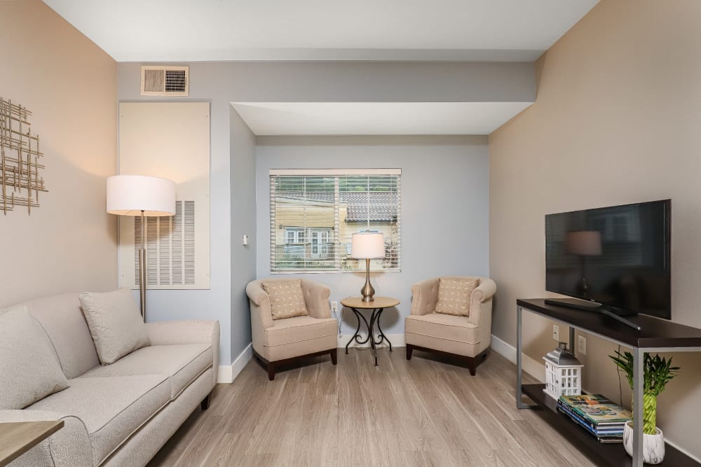 Resident living room with hardwood floors, couches, and chairs at Pacifica Senior Living Poway in Poway, California