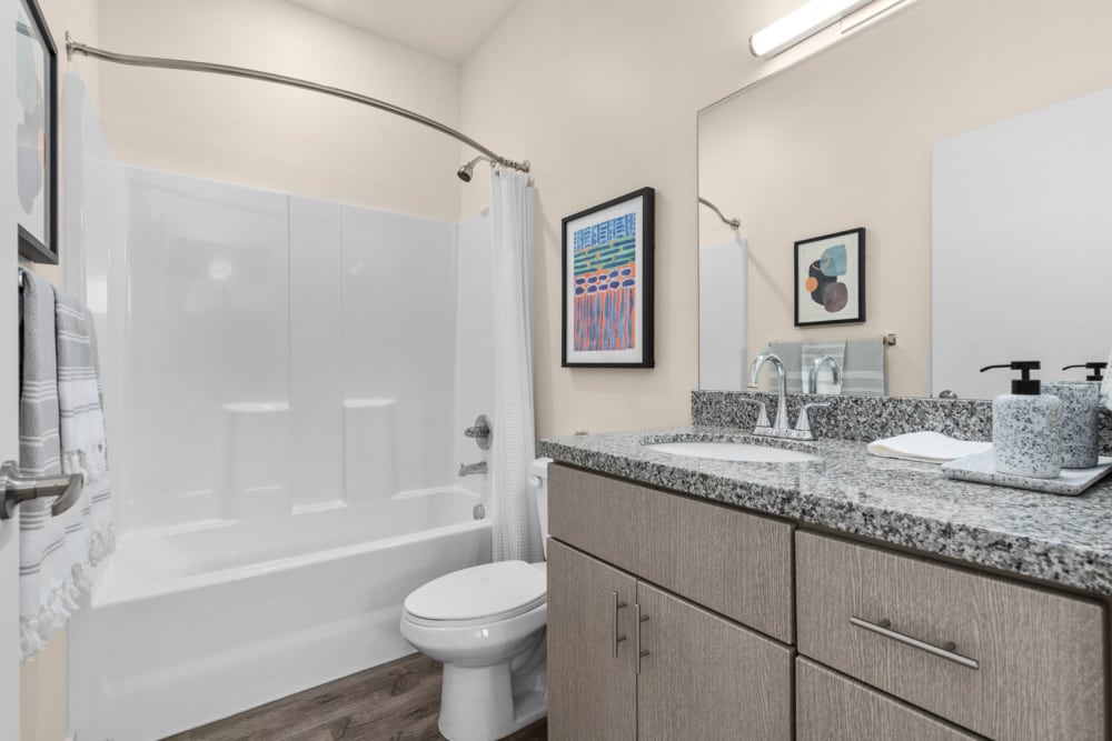 Toilet and bath with wide mirror at Hawthorne Townhomes in South Salt Lake, Utah