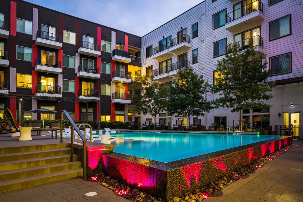 Resort style pool with in-water lounge chairs and tables at Marq on Burnet in Austin, Texas