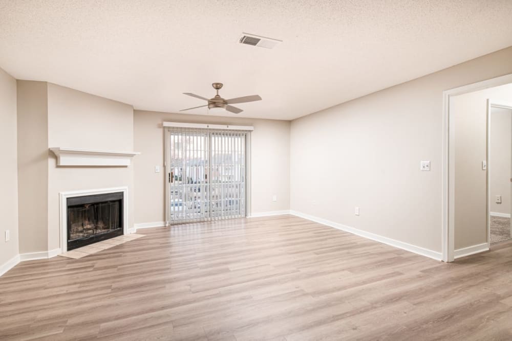 Empty apartment living room with a sliding glass door and a fireplace at The Crescent at 161 in Walls, Mississippi