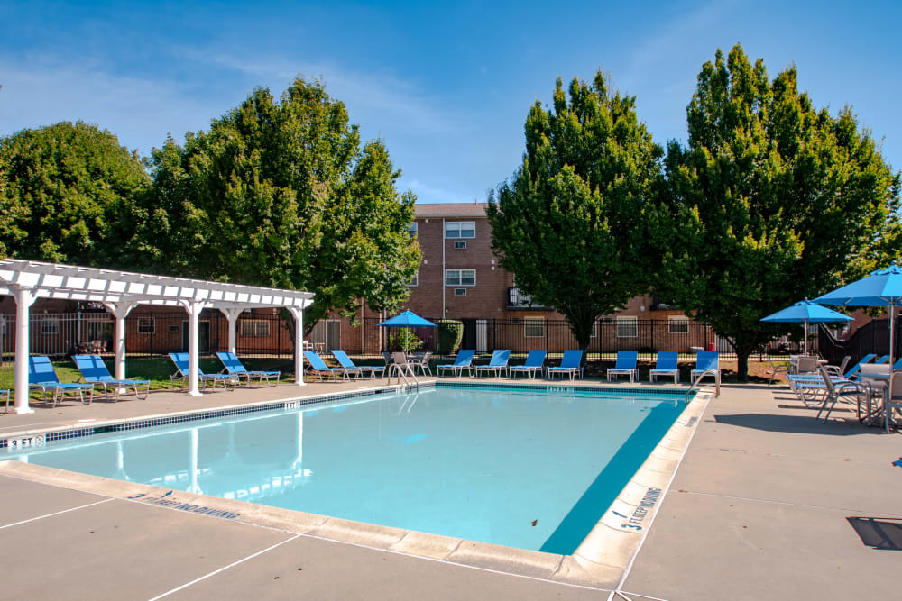 Sunny lawn and swimming pool at Hill Brook Place Apartments in Bensalem, Pennsylvania