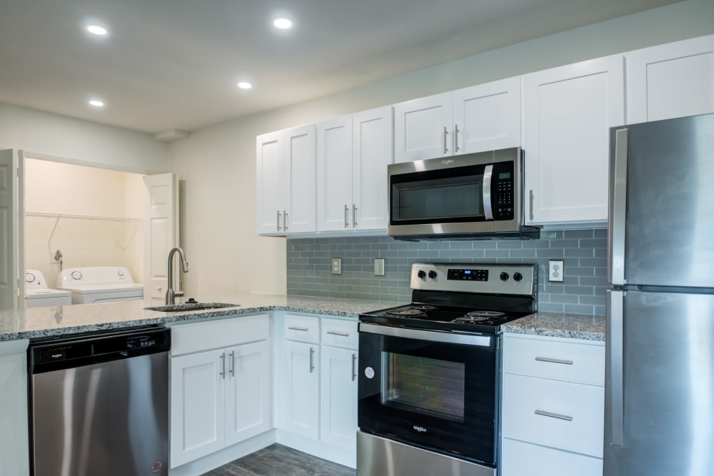 Renovated kitchen with white cabinets and in-unit laundry