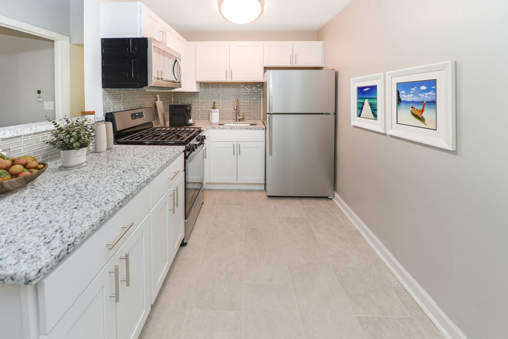 Renovated kitchen with white cabinets and stainless steel appliances at Ocean Terrace Apartment Homes