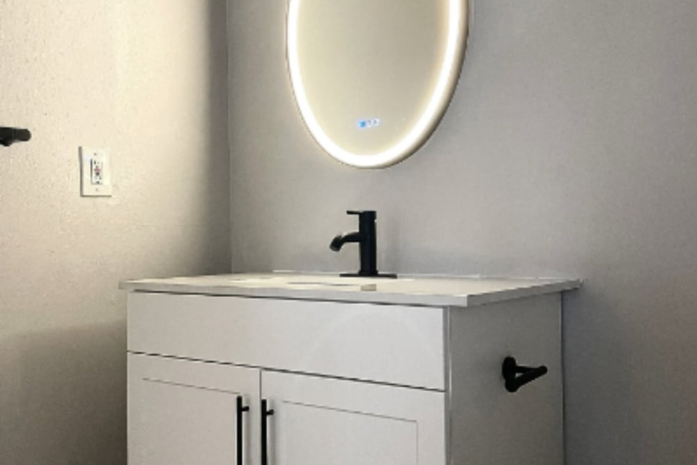 Modern bathroom sink with led light around mirror at Artisan at Lawrenceville in Lawrenceville, New Jersey
