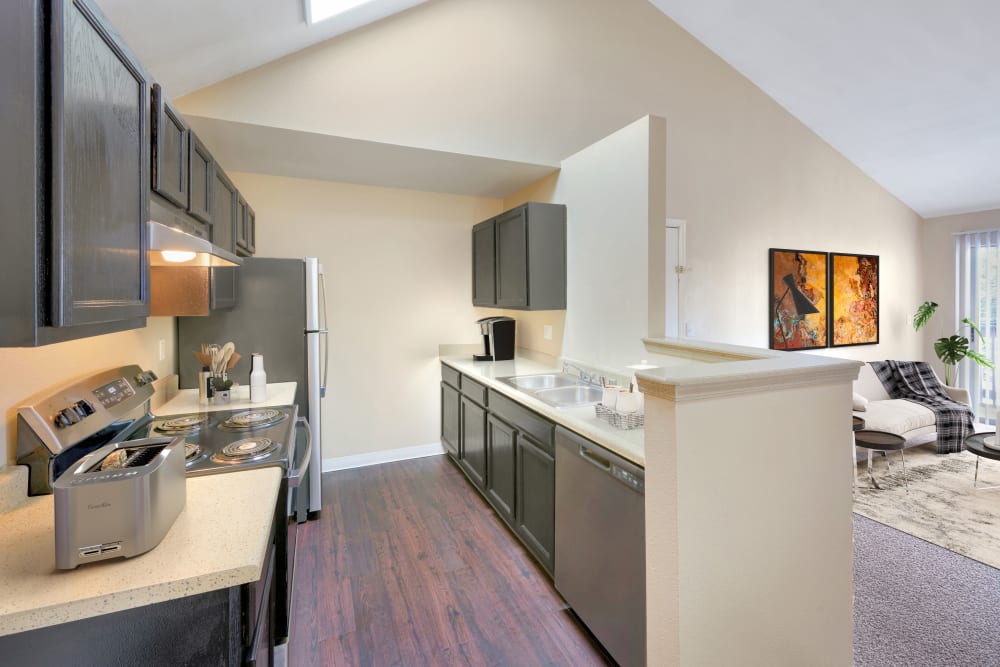 Kitchen with wood-style flooring at Crossroads at City Center Apartments in Aurora, Colorado