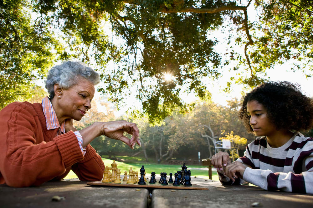 Resident playing chess with family member at The Peaks at Clinton Memory Care