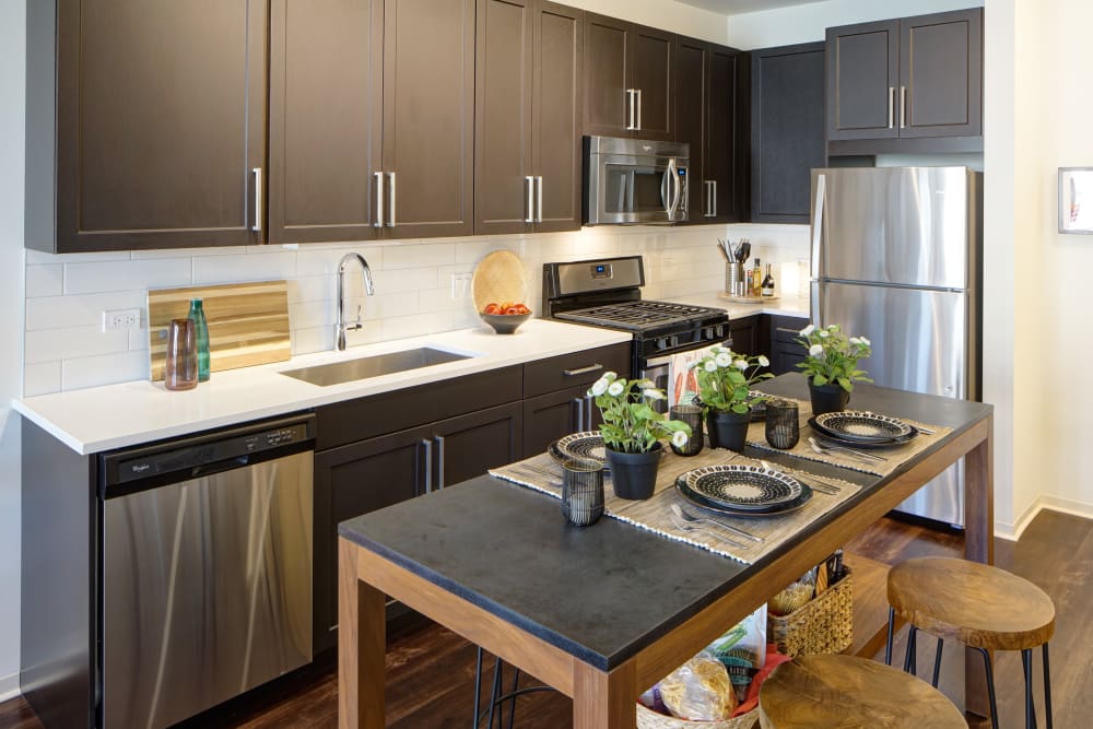Modern kitchen with dark cabinets and marble countertops at Courthouse Square Apartments in Wheaton, Illinois