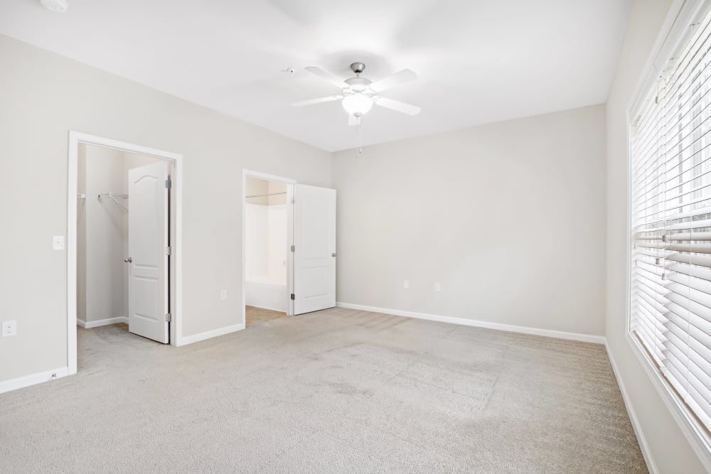Another view of an empty bedroom unit with ceiling fan at Olympus at Jack Britt in Fayetteville, North Carolina