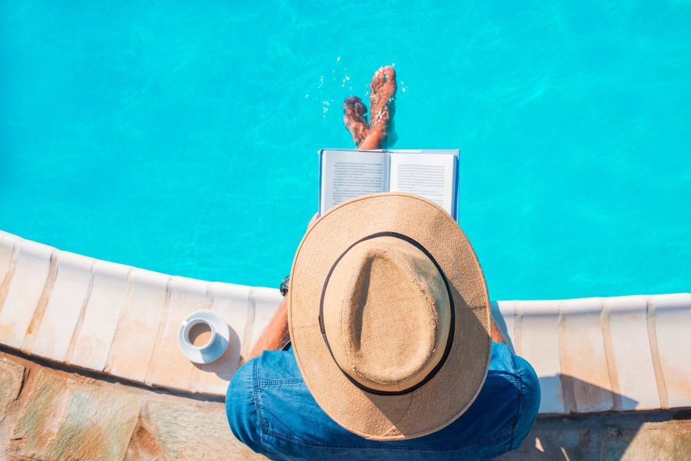 Resident reading poolside at Olympus at Jack Britt in Fayetteville, North Carolina