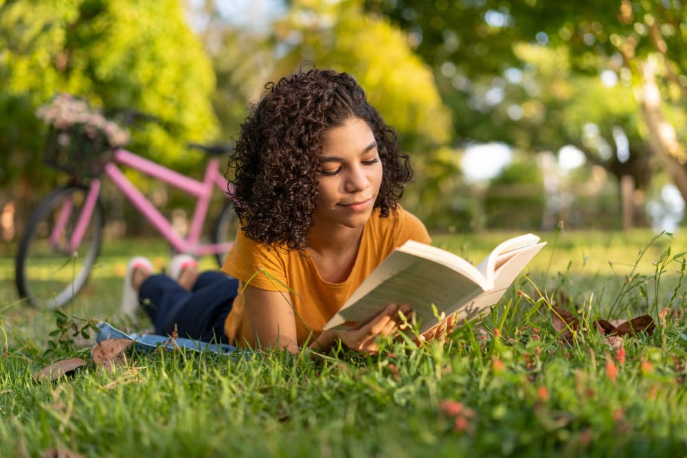 Resident reading in the courtyard at Olympus at Jack Britt in Fayetteville, North Carolina