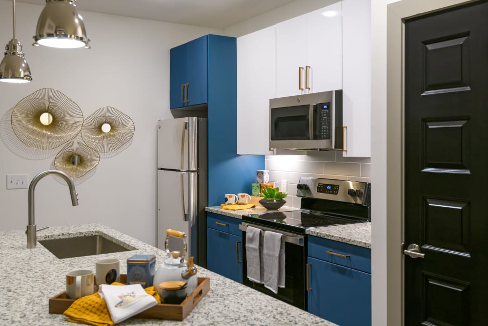 Model kitchen with blue accents at Quill in Atlanta, Georgia