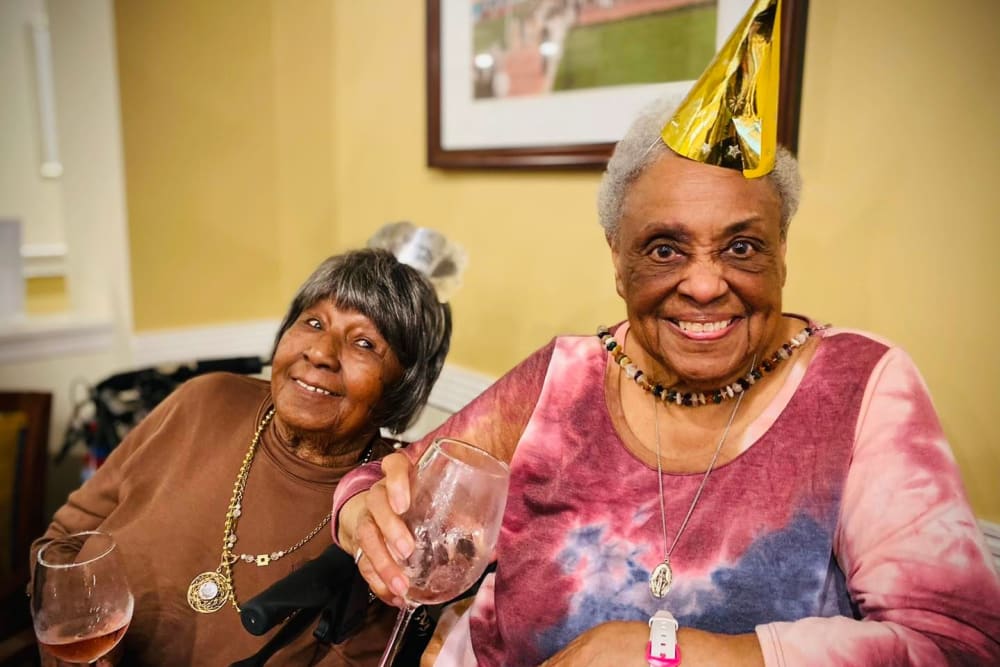 Two residents wearing party hats at Harmony Senior Services