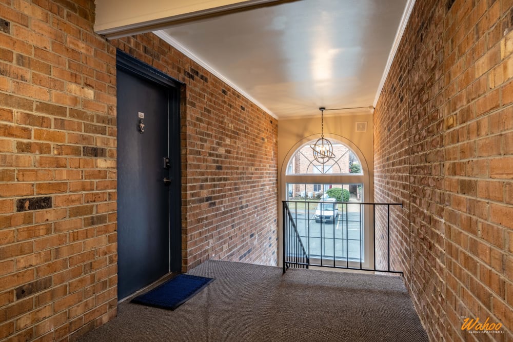 Hallway with stairs with brown brick wall at University Heights in Charlottesville, Virginia