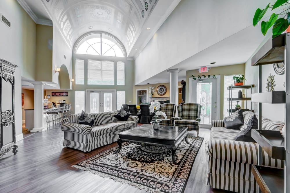 Large furnished lobby with high arched ceilings and a bar at Grove at Stonebrook Apartments & Townhomes in Norcross, Georgia