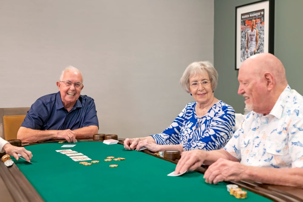 Group of residents playing card games in the game room at Anthology of Highland Park in Dallas, Texas