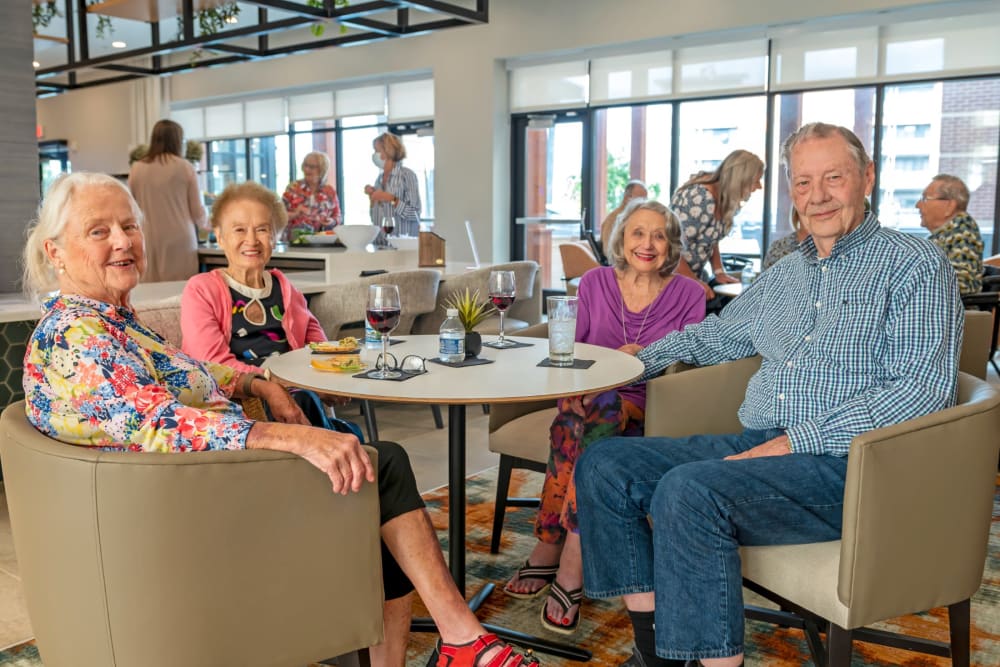 Group of residents enjoying drinks in the dining hall at Anthology of The Arboretum in Austin, Texas